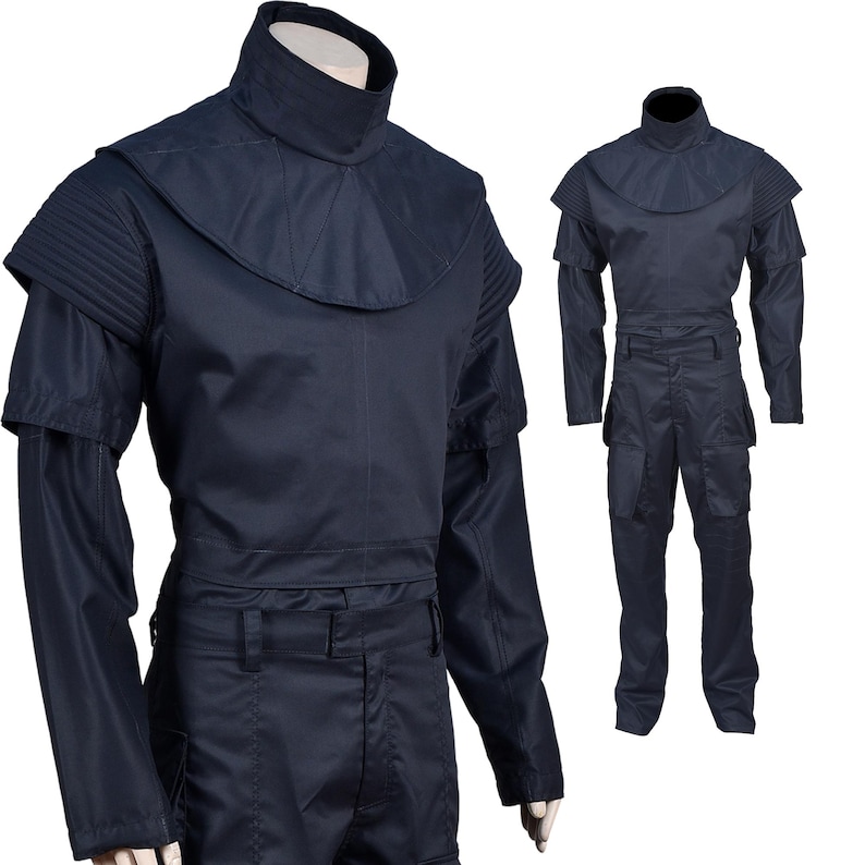 Puede incluir: Un mono azul oscuro con cuello alto y mangas largas. El mono tiene un cintur&oacute;n y bolsillos cargo.