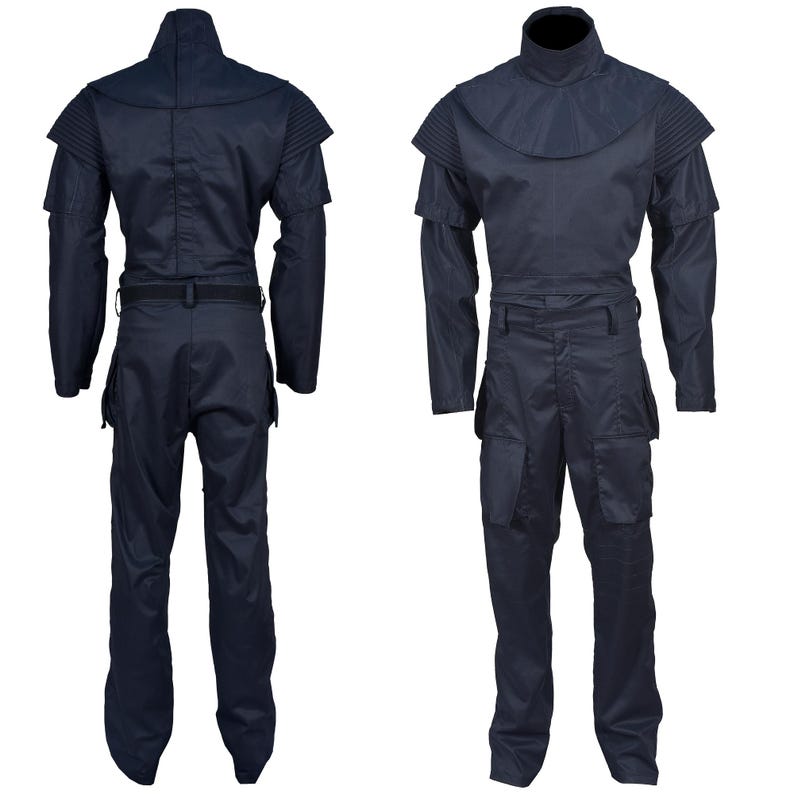 Puede incluir: Un mono azul oscuro con cuello alto y mangas largas. El mono tiene un cintur&oacute;n y bolsillos en las piernas.