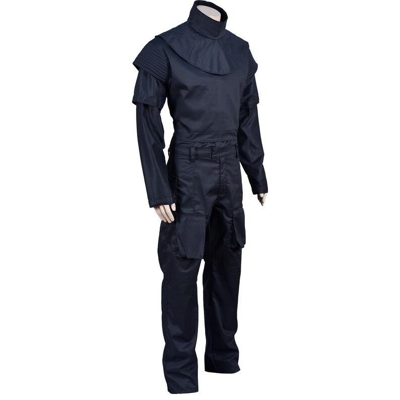 Puede incluir: Un mono negro con cuello alto y mangas largas. El mono tiene un cintur&oacute;n y bolsillos cargo.