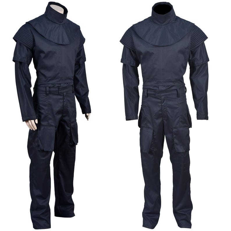 Puede incluir: Un mono azul oscuro con cuello alto y cintur&oacute;n. El mono tiene bolsillos en las piernas y manga larga.