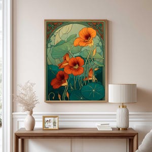 K&ouml;nnte beinhalten: Ein gerahmter Kunstdruck mit stilisierten orangefarbenen Kapuzinerkressebl&uuml;ten und gro&szlig;en gr&uuml;nen Bl&auml;ttern. Das Kunstwerk hat eine Vintage-&Auml;sthetik mit einem gr&uuml;nen und goldenen Rahmen und schafft ein botanisches Thema.