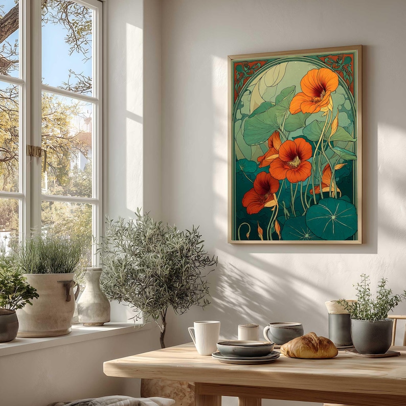 K&ouml;nnte beinhalten: Ein gerahmter Kunstdruck mit stilisierten orangefarbenen Kapuzinerkressebl&uuml;ten und gr&uuml;nen Bl&auml;ttern. Das Kunstwerk hat eine Vintage-&Auml;sthetik mit einem goldenen Rahmen und einem gr&uuml;nen und orangefarbenen Rand. Der Druck wird an einer wei&szlig;en Wand in einem hellen Raum angezeigt.