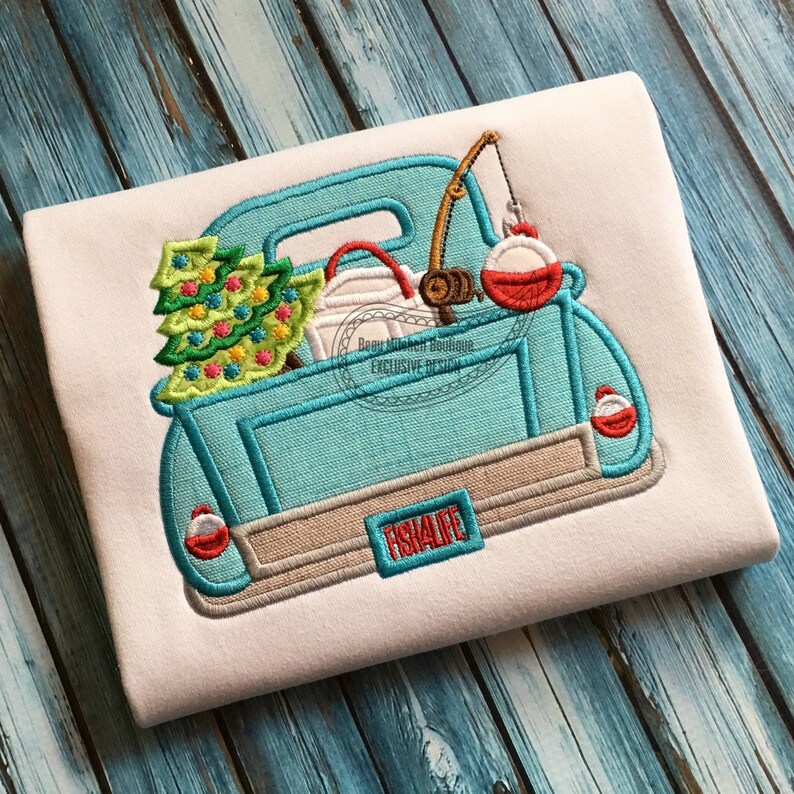 May include: Embroidered design of a light blue pickup truck bed filled with a Christmas tree, fishing gear, and a red and white bobber. The truck bed has the text "FISH4LIFE" on the back. The design is on a white background.