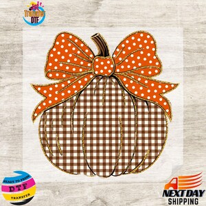 May include: A pumpkin graphic featuring a brown and white gingham pattern on the body and a large orange bow with white polka dots on top. The design includes a gold glitter outline around the pumpkin and the bow, with a brown stem at the center.
