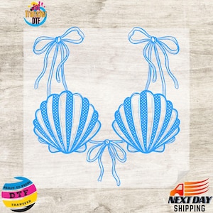 May include: A blue line art graphic of a seashell bikini top featuring two scalloped shell cups with dotted patterns, tied together with thin ribbons at the shoulders and center, presented as a transfer design on a clear backing sheet.