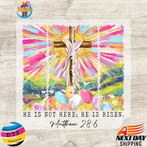 May include: A colorful Easter-themed DTF transfer featuring a wooden cross with a draped cloth, surrounded by pastel-colored Easter eggs and a vibrant background. The text reads "HE IS NOT HERE; HE IS RISEN. Matthew 28:6."