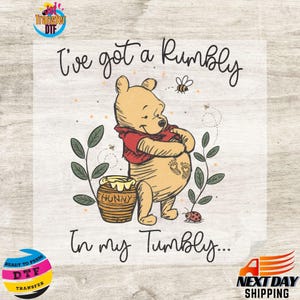 May include: A DTF (Direct to Film) transfer featuring Winnie the Pooh with the text "I've got a Rumbly in my Tumbly...". The design includes a cartoon illustration of Pooh Bear, a honey pot, bees, and a ladybug. The transfer is ready to press.