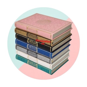 May include: A stack of colorful books with gold-colored edges. The top book is pink, followed by gold, black, blue, silver, white, and teal. The books have gold lettering and are stacked on top of each other.
