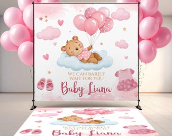 May include: A pink baby shower backdrop and floor decal set. The backdrop features a teddy bear on a cloud with balloons, shoes, and a dress. The text reads "We can barely wait for you Baby Liana". Pink balloons are on either side.