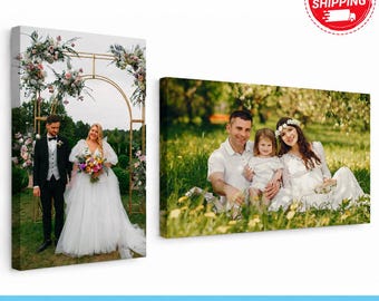 May include: Two rectangular canvas prints featuring photographic portraits. The left vertical print shows a couple standing under a floral archway. The right horizontal print shows a family of three sitting in a grassy field with trees.