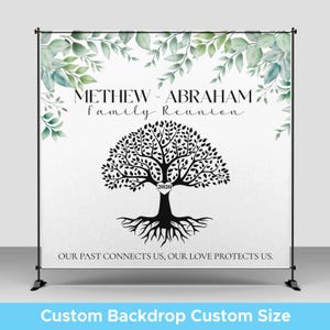 May include: A white backdrop banner on a black stand featuring green watercolor leaves at the top, the text METHEW - ABRAHAM family Reunion, a black tree silhouette with a heart containing 2026, and the text OUR PAST CONNECTS US, OUR LOVE PROTECTS US.