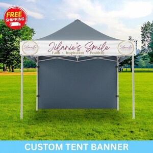May include: A gray custom tent banner with the text "Jilanie's Smile" and the words "Faith, Inspiration, Positivity." The banner is displayed on a white frame tent on a grassy field. The words "Custom Tent Banner" are at the bottom.