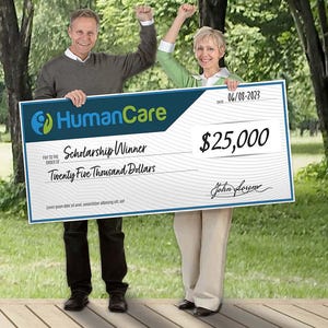 May include: A large check with the HumanCare logo, the words "Scholarship Winner," and the amount of $25,000. Two people are holding the check, celebrating in an outdoor setting with trees in the background.