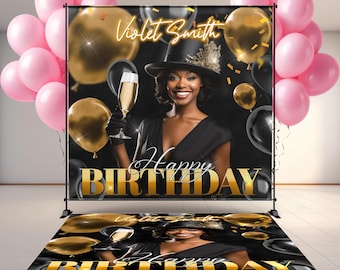 May include: A custom birthday backdrop and floor decal set. The backdrop features a woman in a black dress and hat, holding a champagne glass, with gold and black balloons. The words "Happy Birthday" are in gold. Pink balloons are on the left.
