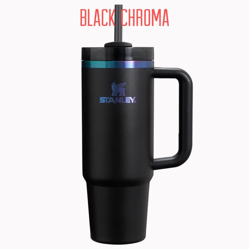 Pu&ograve; includere: Bicchiere Stanley nero con manico e cannuccia. Il bicchiere ha un coperchio nero e una fascia di colore iridescente nella parte superiore. Il logo Stanley &egrave; visibile sul davanti. Il testo "BLACK CHROMA" &egrave; in alto.