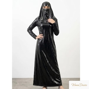 Peut inclure: Longue robe noire intégrale à manches longues et coiffe assortie. La robe a une surface brillante et réfléchissante. Le modèle porte un niqab, un voile qui couvre le visage, laissant les yeux visibles.