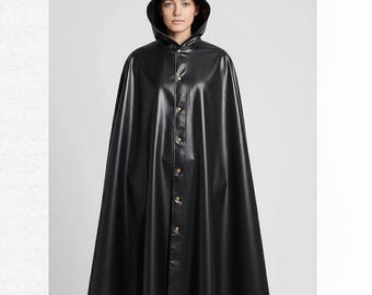 May include: A black hooded cloak with a shiny, leather-like appearance. The cloak features a button-up front with gold-colored buttons and a wide, flowing design. The hood is pointed, and the garment is worn by a person.