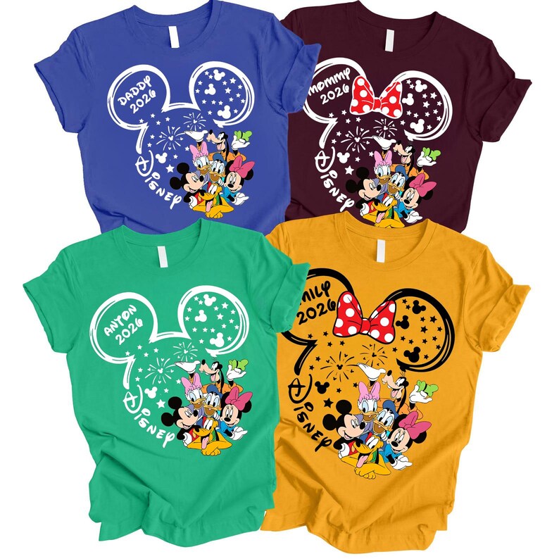 Puede incluir: Cuatro camisetas coloridas con tem&aacute;tica de Disney. Cada camiseta presenta un dise&ntilde;o de cabeza de Mickey Mouse con texto y personajes de Disney. Los colores incluyen azul, granate, verde y amarillo. El texto incluye "Daddy 2026", "Mommy 2026", "Anton 2026" y "Family 2026".
