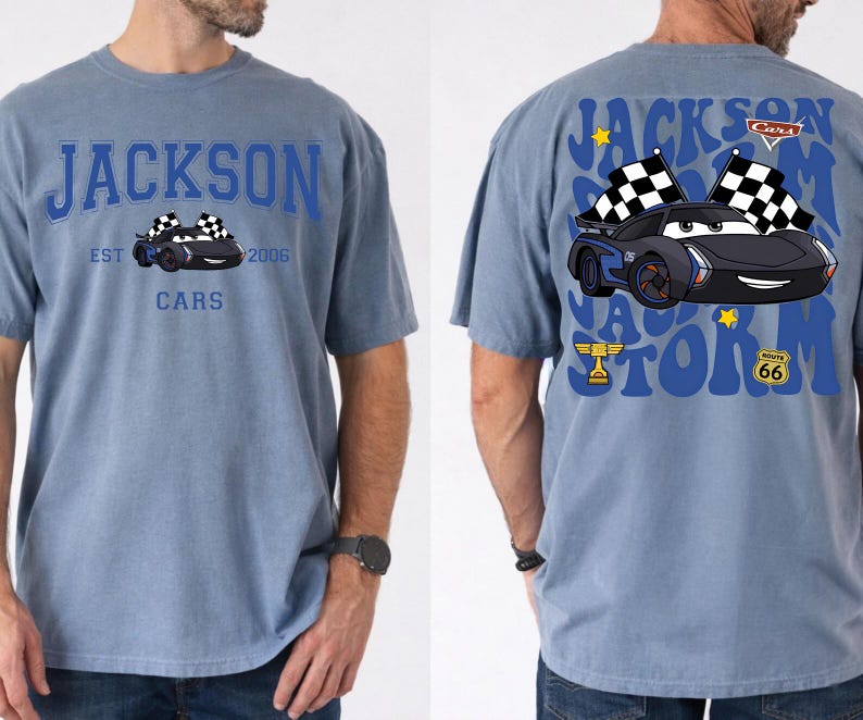 Pode incluir: Uma camiseta azul com um design de carro de desenho animado. A frente da camiseta exibe o texto "JACKSON CARS EST 2006" acima de um gr&aacute;fico de carro. A parte de tr&aacute;s da camiseta tem um gr&aacute;fico de carro maior com o texto "JACKSON STORM" e "ROUTE 66".