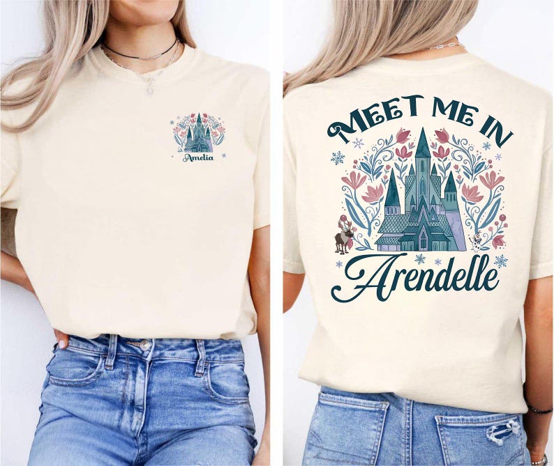 Op de afbeelding: Cr&egrave;mekleurig T-shirt met een ontwerp op de voor- en achterkant. De voorkant heeft een kasteelafbeelding en de naam "Amelia". De achterkant toont de tekst "Meet Me In Arendelle" met een kasteelillustratie en bloemmotieven.