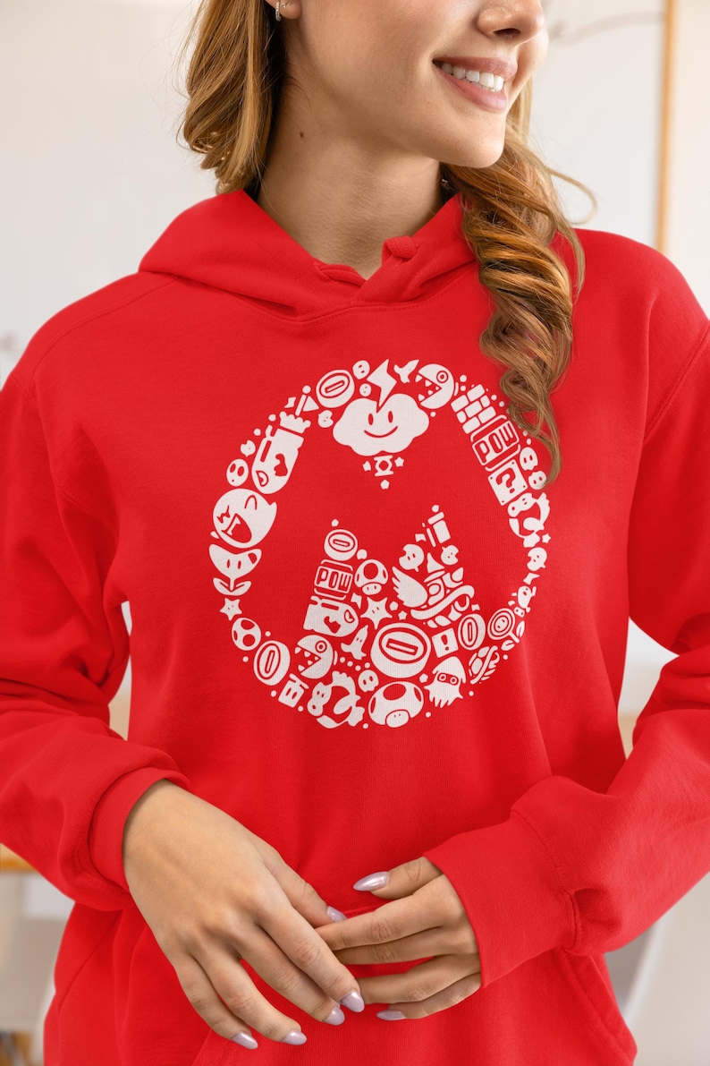May include: A red hoodie featuring a white graphic design of various video game characters and icons arranged in a circular pattern. The design includes a smiling cloud, mushrooms, and the word "POW".