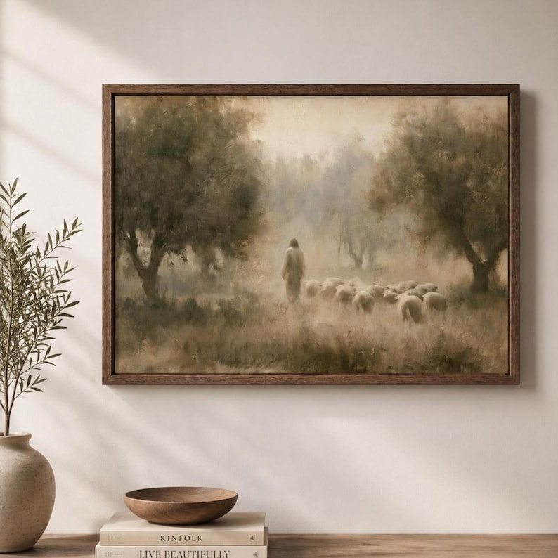 Good Shepherd Christian wall art displayed above a console table in a warm neutral room with natural decor.