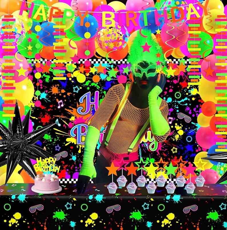 May include: A neon-themed birthday party decoration set featuring a black backdrop with colorful paint splatters, a Happy Birthday banner, neon balloons, star-shaped cupcake toppers, a black star balloon, and a small pink cake on a table.