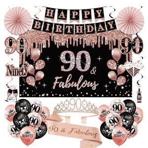 May include: A black and rose gold 90th birthday party decoration set. Includes a banner that says "Happy Birthday", balloons, a sash, a tiara, and a backdrop that says "90 & Fabulous". There are also paper fans and decorative swirls.