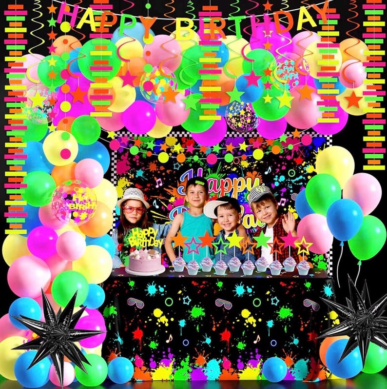 May include: A neon-themed party decoration set featuring a Happy Birthday banner, colorful balloons in pink, blue, yellow, and green, star-shaped cake toppers, and a black tablecloth with a vibrant paint splatter pattern and musical note graphics.