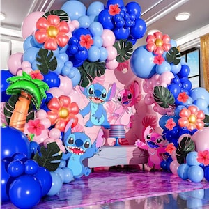 May include: A vibrant party backdrop featuring a balloon arch in shades of blue and pink, adorned with large coral flowers, green leaves, and character cutouts. A palm tree balloon adds to the tropical theme.