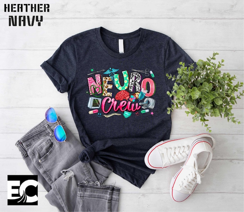 a navy blue t-shirt with a colorful graphic design, a pair of jeans, a pair of sunglasses, a potted plant, and a pair of white sneakers, all laid out on a white background.