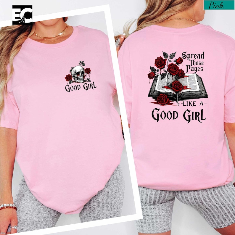 A woman wearing a pink t-shirt with a skull and rose design, and text that says "spread those pages like a good girl".