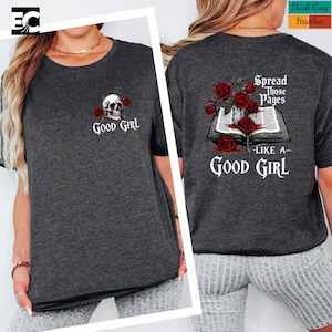 a woman wearing a gray t-shirt with a graphic design on the back. The design includes a skull, roses, and the text "spread those pages like a good girl".