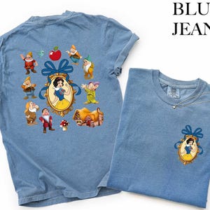 a blue t-shirt with a design of Snow White and the Seven Dwarfs, along with various other cartoon characters.