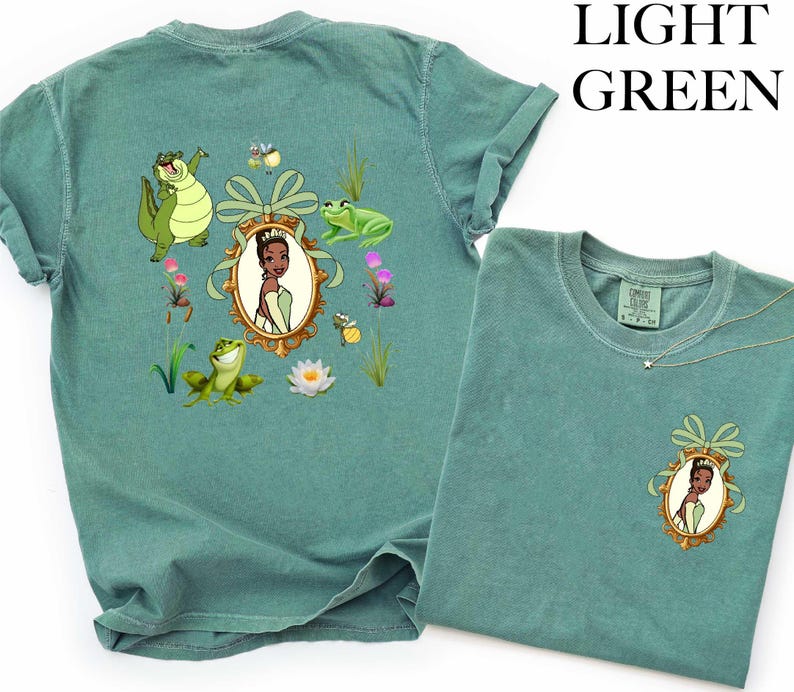 a green t-shirt with a design of a princess surrounded by various cartoon characters and elements, such as a frog, flowers, and a bow.