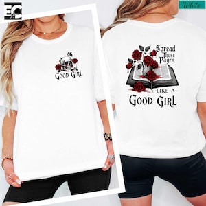 A white t-shirt with a graphic design on the back, featuring a skull and roses, along with the text "spread those pages like a good girl".