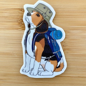 Puede incluir: Un beagle de dibujos animados con un sombrero marrón y una mochila azul. El beagle está sentado con la cabeza inclinada hacia arriba y mirando hacia la derecha.