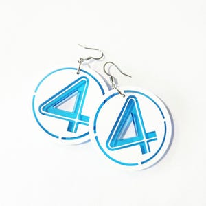 May include: A pair of white circular earrings with a blue number four inside each circle. The earrings have silver hooks.
