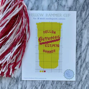 May include: Needlepoint pattern for a yellow cup with the text "Yellow Gallettes Est. 1976 Hammer" in red. The pattern is for 18 mesh canvas.
