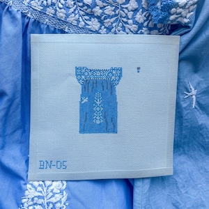 May include: A light blue canvas with a design of a blue dress with white embroidery. The canvas has the text "BM-05" in the bottom left corner.