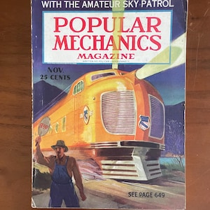 May include: A vintage Popular Mechanics magazine cover from November, priced at 25 cents. The illustration features a bright orange streamlined train and a person in blue overalls holding a stop sign. The text reads With The Amateur Sky Patrol.