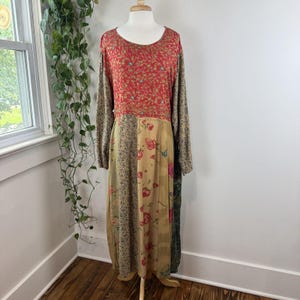 May include: A long-sleeved dress featuring a patchwork design with a red floral bodice and a skirt composed of multiple panels in beige, brown, and green with various floral and botanical patterns, including large pink roses and small intricate prints.