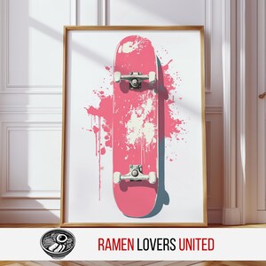 May include: A framed art print featuring a pink skateboard design with a splash of pink paint. The skateboard has silver trucks and wheels. The text "RAMEN LOVERS UNITED" is at the bottom of the frame.