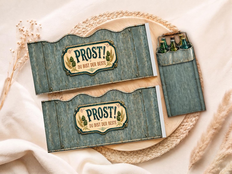 May include: Two blue-grey beer bottle carriers with the text "PROST! DU BIST DER BESTE" in a decorative frame. A matching carrier holds several green bottles. The items are on a wooden tray with a woven border.