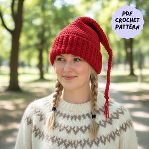 May include: A bright red crochet hat with a long, dangling tassel. The hat is worn by a person with blonde braids, and the image includes a light purple circle with the text "PDF CROCHET PATTERN". The person is wearing a cream-colored sweater with a geometric pattern.