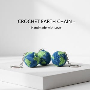 Puede incluir: Tres llaveros de la Tierra hechos a mano con ganchillo. Cada llavero presenta un diseño de globo terráqueo azul y verde, sujeto a un llavero plateado. El texto "CROCHET EARTH CHAIN - Handmade with Love" se muestra arriba.