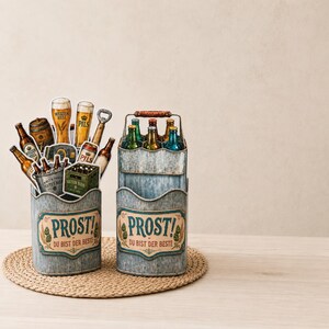 May include: Two metal beer caddies with the word "PROST!" and "DU BIST DER BESTE" printed on them. One caddy holds beer bottles and cutouts of beer glasses and bottles. The other caddy holds beer bottles. The caddies sit on a woven mat.