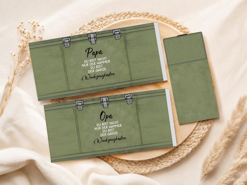 May include: Two olive green gift boxes with silver clasps and the German text "Papa" and "Opa". The text on the boxes reads "You are not just the hammer, you are the whole toolbox."