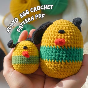 Può includere: Due figure a forma di uovo all'uncinetto gialle con orecchie, occhi neri e un becco rosso. La figura più grande ha una striscia verde al centro. Il testo "FLUTO EGG CROCHET PATTERN PDF" è in lettere bianche.