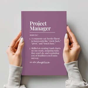 May include: A purple notebook with the words "Project Manager" in white. The text below defines the role with humorous descriptions, including "corporate cat-herder" and "creating Gantt charts no one reads." The text also includes "see also: Angelica."